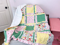 Floral yellow and pink girl rag quilt for sale, featuring soft fabric with a green accent. Available in sizes from toddler to throw and twin, this cozy quilt is perfect for girls&#39; bedding, offering warmth and style in a floral design
