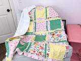Floral yellow and pink girl rag quilt for sale, featuring soft fabric with a green accent. Available in sizes from toddler to throw and twin, this cozy quilt is perfect for girls&#39; bedding, offering warmth and style in a floral design