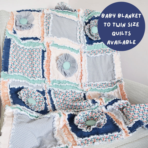 A beautiful floral baby girl rag quilt in blush, blue, and sage green. This handcrafted quilt is the perfect addition to any baby girl&#39;s nursery, bringing warmth, comfort, and a touch of elegance. Available in sizes from baby blanket to twin size.